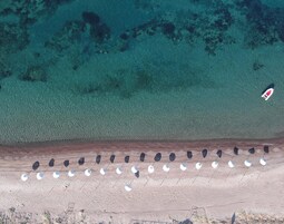 Una playa cerca, sillas reclinables de playa, sombrillas