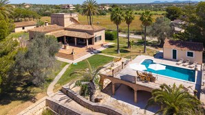 Eine Villa mit Schwimmbad, Terrasse und einer Stegbrücke.
