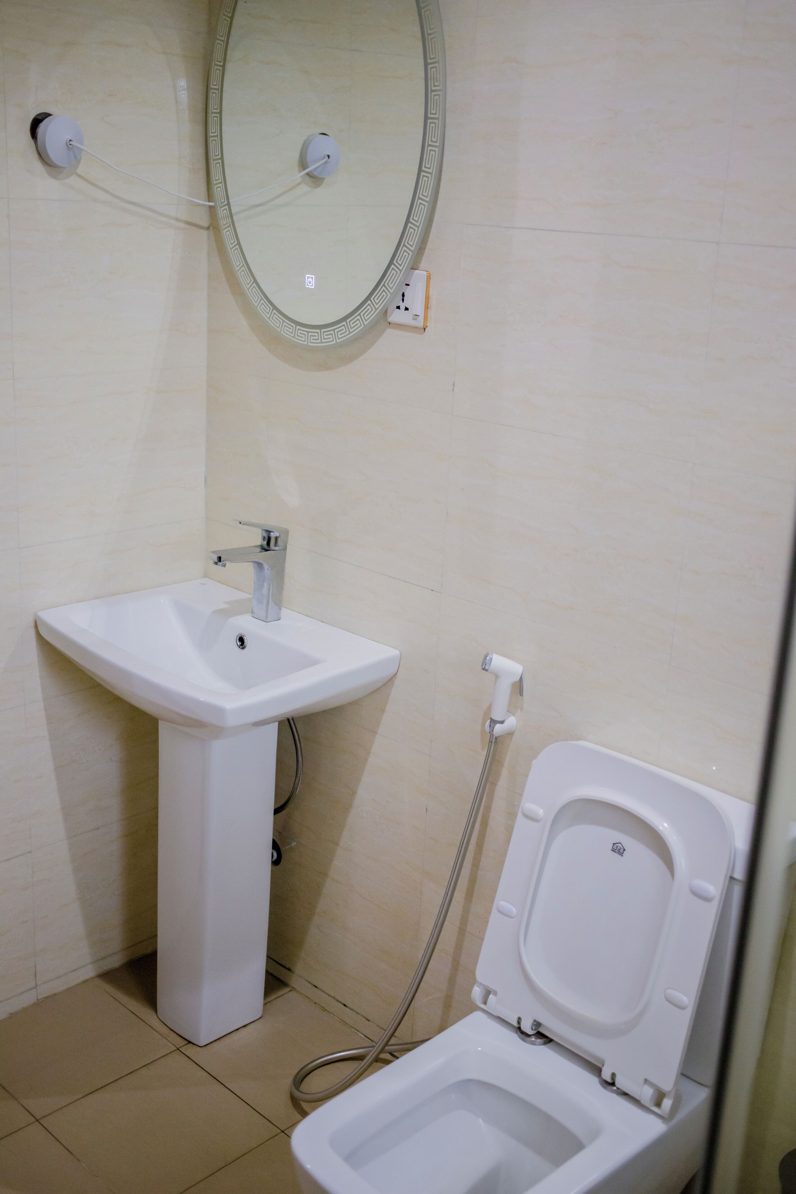 Un bagno con lavandino, WC e specchio.