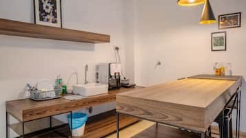 Cozinha moderna com bancada de madeira, pia e luminária pendente.