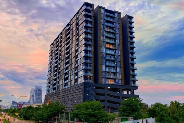 A tall, modern high-rise building with multiple floors and balconies.