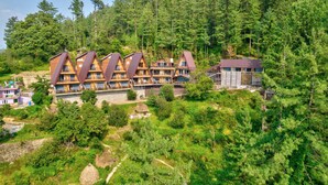 A lodge with multiple wooden cabins, surrounded by dense forest. - Katson Courtyard Mashobra (Shimla)