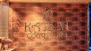 A wooden wall with the text 'KATSON COURTYARD' and a decorative metal sign. - Katson Courtyard Mashobra (Shimla)