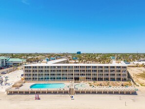 A hotel with a large pool, multiple balconies, and a view of the surrounding area. - Ocean View Condo | Beachfront Resort Escape (Daytona Beach)