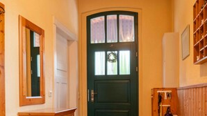 A hallway with a wooden door, a mirror, a wooden dresser, and a radiator. - Holiday Home 'Ivenack Old School' with Private Terrace and Private Garden (Ivenack)