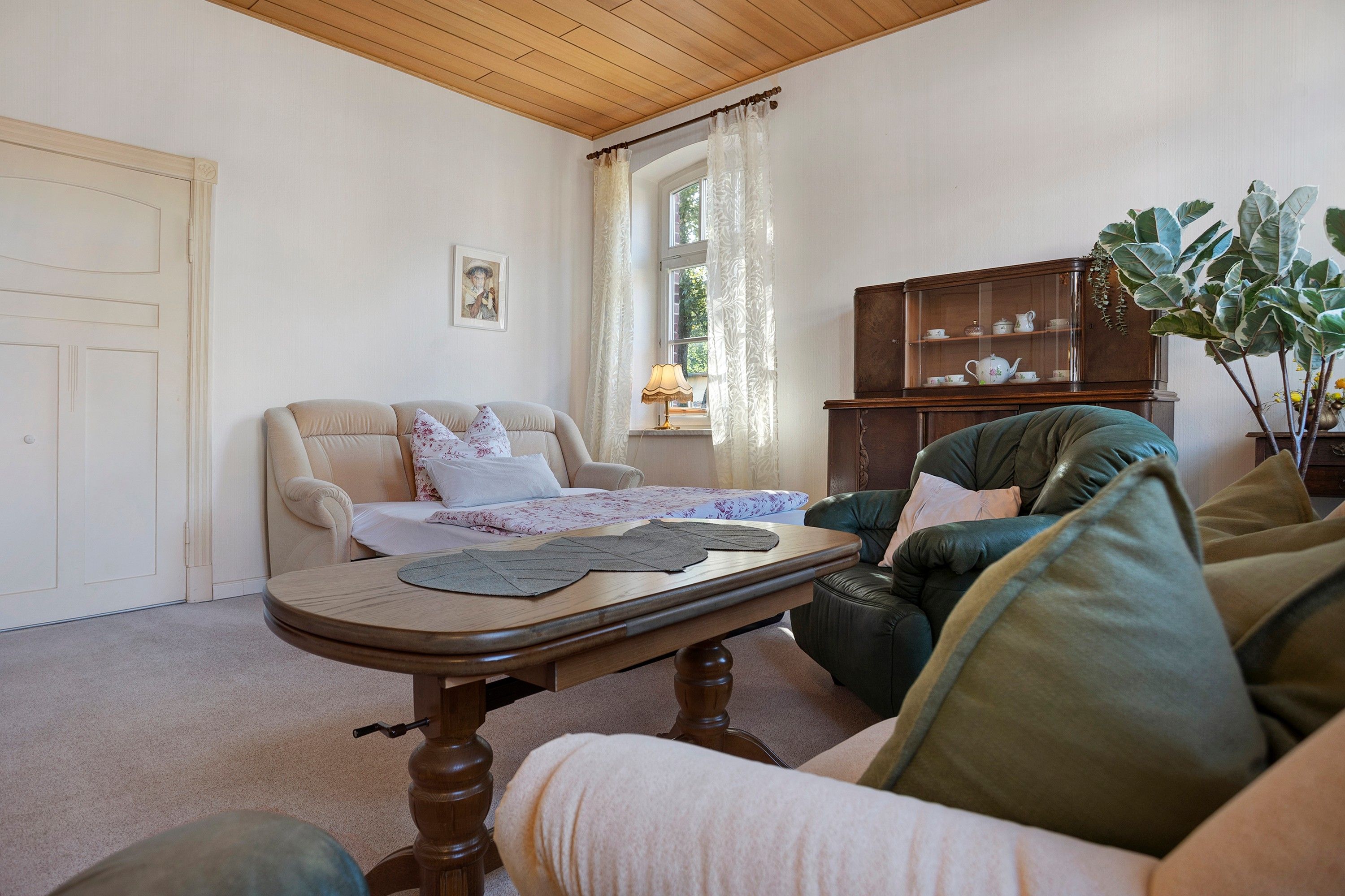 A living room with a sofa, a table, a cabinet, and a door.