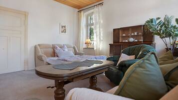 A living room with a sofa, a table, a cabinet, and a door.
