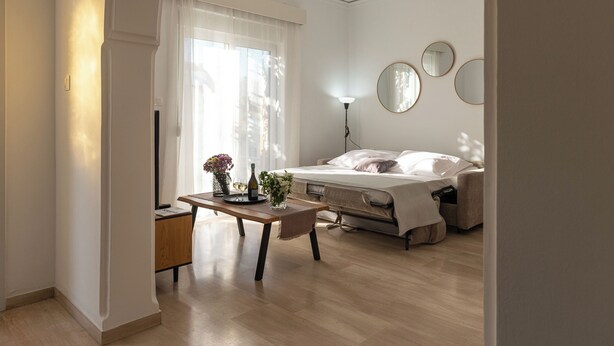 Une chambre à coucher avec un lit, des tables de chevet, une lampe de chevet et une fenêtre avec des rideaux.