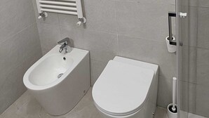 Kylpyhuone, jossa on bidee, wc ja pyyhekoukku.