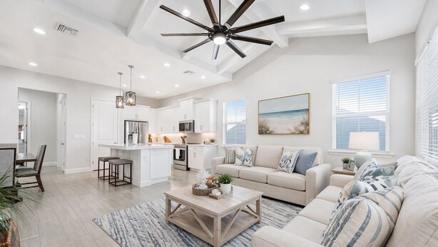 A spacious living area with a large sofa, a coffee table, and a kitchen in the background. - Naples Luxury Cottage-Stylish 2BR in Premier Luxury Community (Naples)