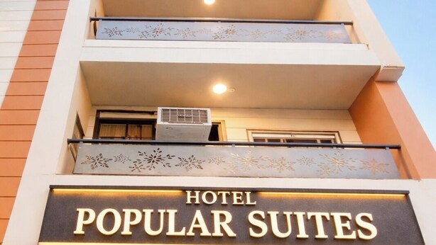 A hotel entrance with a sign reading 'HOTEL POPULAR SUITES'. - Hotel Popular Suites (New Delhi)