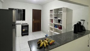 A kitchen with a refrigerator, stove, and a counter with bananas. - Great value for money in Chapada! (Seabra)