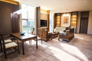 Un amplio salón con una mesa de comedor, sofás y un televisor.