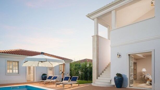 A swimming pool with lounge chairs and umbrellas, a white building with a staircase, and a potted plant. - Villa Celeste - Casa del Sole (Tar-Vabriga)