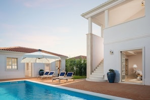 A swimming pool with lounge chairs and umbrellas, a white building with a staircase, and a potted plant. - Villa Celeste - Casa del Sole (Tar-Vabriga)