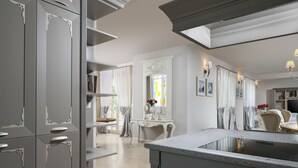 A modern kitchen with grey cabinetry, a central island, and a dining area with a table and chairs. - Villa Celeste - Casa del Sole (Tar-Vabriga)
