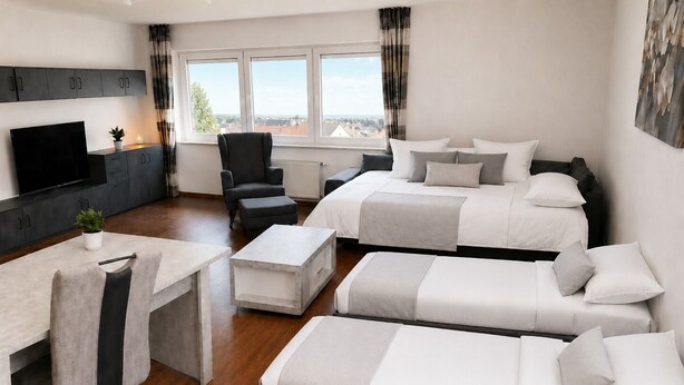 Une chambre d’hôtel avec un lit, un bureau, une chaise et un téléviseur.