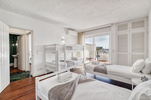 A hotel room with bunk beds, a bathroom with a sink, and a view of the city. - Marina View Apartment (Loulé)