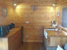 Un interior de madera con un reloj, una zona de bar y un lavabo.