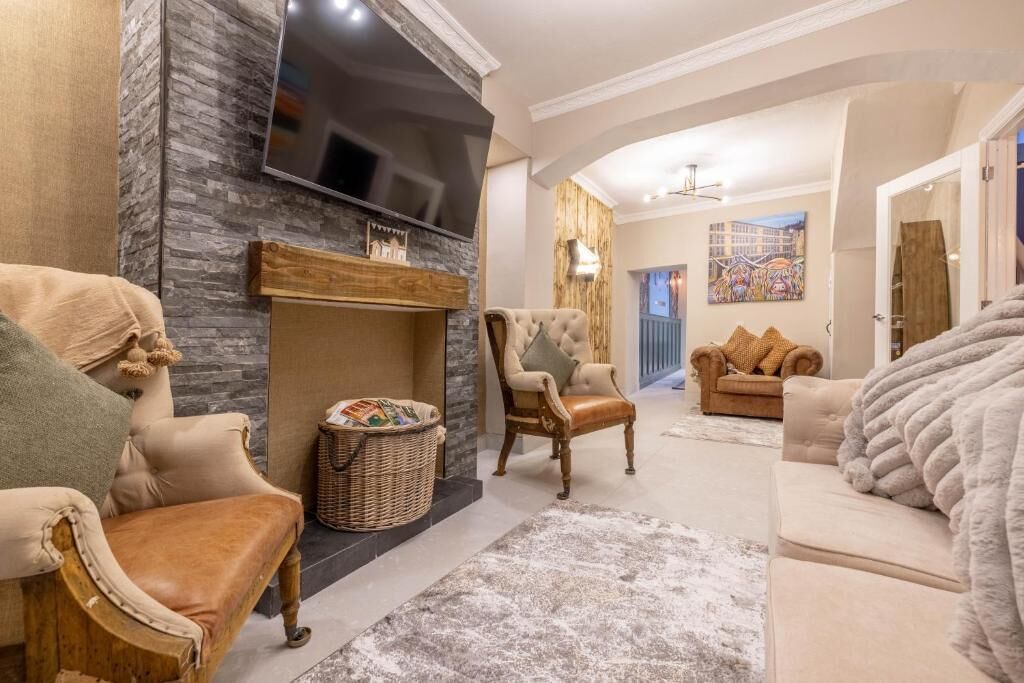 A living room with a fireplace, a television, and comfortable seating.