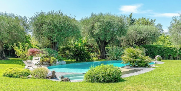 A landscaped garden with a swimming pool, stone seating, and various plants. - Le Mas du Pas de Sénès (La Colle-sur-Loup)