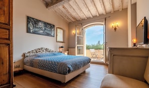 A bedroom with a bed, a painting, a door leading to an outdoor area, and a view of the sky. - Le Mas du Pas de Sénès (La Colle-sur-Loup)