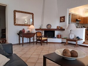Ein Wohnzimmer mit Kamin, Esstisch und Sofa.