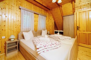 A wooden-paneled room with a bed, bedside tables, and a door. - Paradise in the countryside - pool, whirlpool & absolute tranquillity (Breze)