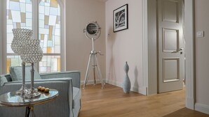A room with a sofa, a table with a lamp, a tripod, a framed picture, and a door. - Villa Bianca - Casa del Sole (Tar-Vabriga)