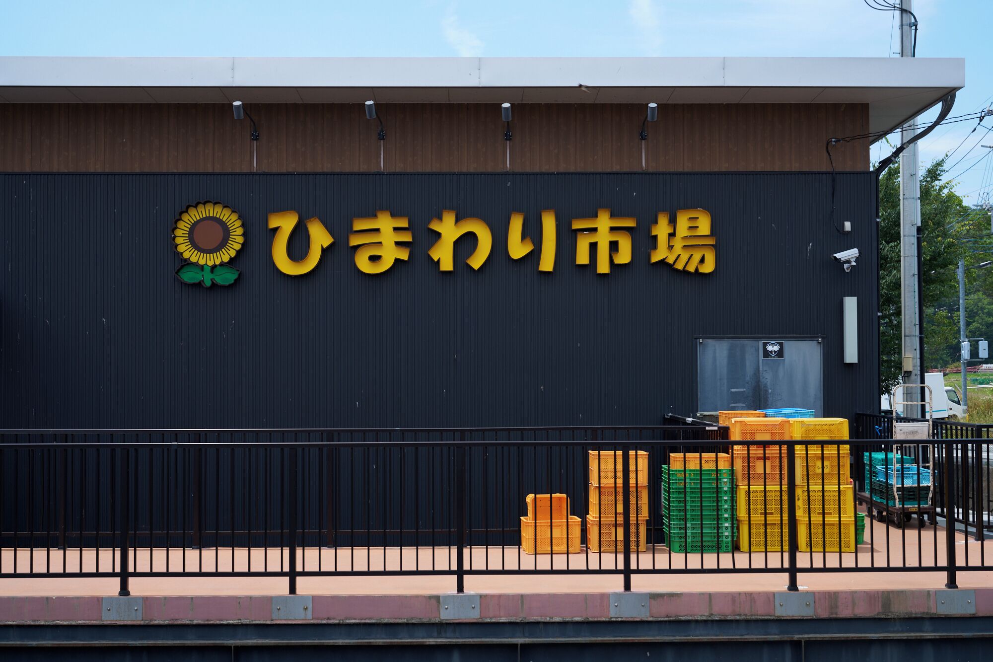 A building with a dark facade and a large yellow sign with Japanese characters.