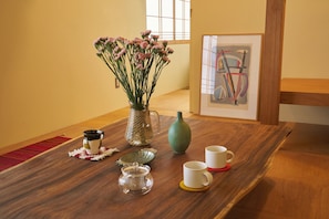 A wooden table with a vase of flowers, a teapot, and two cups. - Kaneko sanso KK1 (Hokuto city Oizumi cho Nishiide)