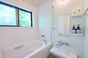 A modern bathroom with a bathtub, a shower, a sink, and a window. - Kaneko sanso KK1 (Hokuto city Oizumi cho Nishiide)