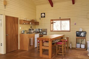 Ett kök med träskåp, en spis och ett matbord med stolar.
