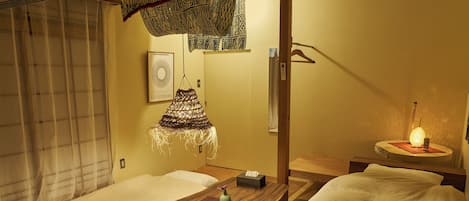Una habitación tradicional japonesa con suelo de tatami, una mesa de madera baja y una decoración textil colgante.