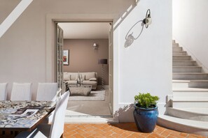 A modern interior with a dining area, a staircase, and a living room visible through an open doorway. - Villa Bianca - Casa del Sole (Vabriga)