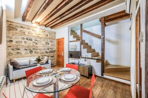 Un espace repas agrémenté d’un mur en pierre, d’un escalier et d’un aménagement intérieur moderne.