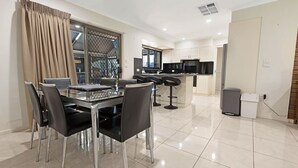 A modern kitchen with white cabinets, a black countertop, and a stainless steel range hood. - Maffra Retreat: Kick back and enjoy country Gippsland (Maffra)