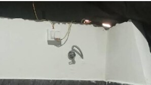 Un baño con inodoro, ducha y enchufe en la pared.
