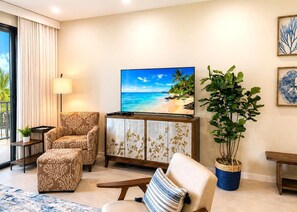 A living room with a TV, two patterned sofas, a coffee table, a potted plant, and a view of the ocean. - Napili Point 2 Water Front Villas, Sleeps 10 | Car Incl. w/ 6 nights | ML-4031 by KBM (Lahaina)