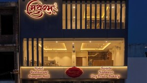 Un edificio con un letrero que indica 'Marham Sweets' y 'Nadhram Banquet Hall' en la planta baja.