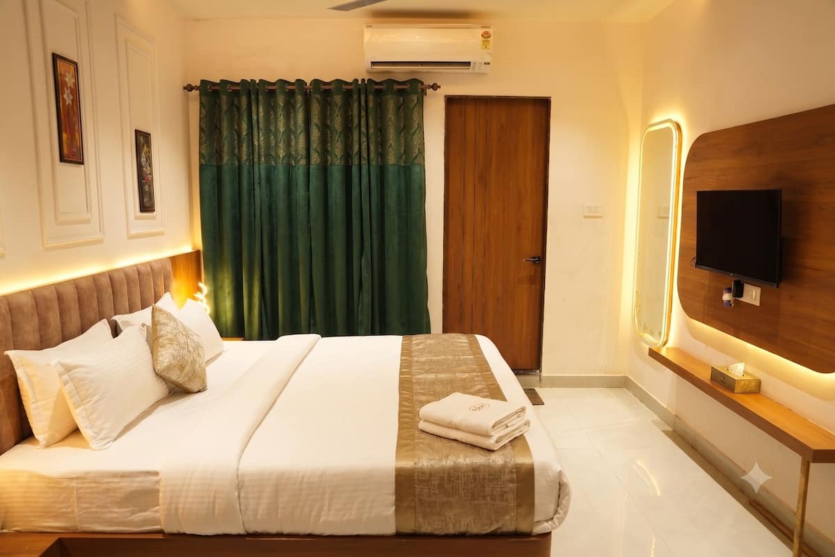 Une chambre d’hôtel équipée d’un lit, d’une télévision, d’un climatiseur et d’une porte en bois.