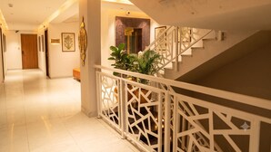 Interior moderno de hotel con escalera, pasillo y área de recepción.