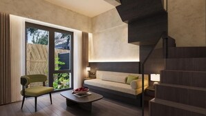 Um interior moderno com um sofá, uma poltrona, uma mesa de centro e uma escada.