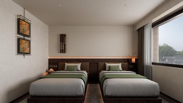 Quarto de hotel moderno com duas camas, uma janela grande e obras de arte na parede.