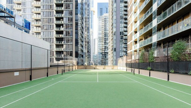 Un campo da tennis interno circondato da palazzi residenziali.