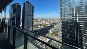 Un edificio alto con vista chiara sullo skyline urbano, che include altri grattacieli e una strada trafficata sottostante.