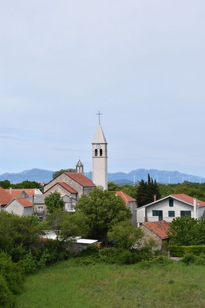 Una chiesa con un campanile, circondata da edifici residenziali e vegetazione.