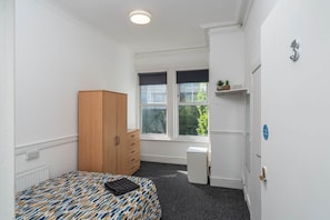 A room with a bed, wardrobe, radiator, windows, and a door with a number. - Room 3 - The Archers (Southampton)