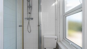 A small, enclosed shower area with a glass door, a toilet, and a window with frosted glass. - Room 2 - The Archers (Southampton)