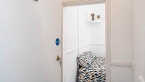 A room with a bed, a door with a fire door sign, and a number '2' on the wall. - Room 2 - The Archers (Southampton)